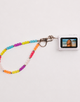 Mini digital camera with rainbow beaded lanyard showing photo on screen