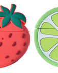 Two fruit silicone AirPods Pro cases and cleaning tool set on white background with seed and front detail