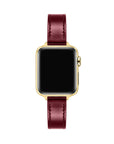 Apple Watch with Cherry Lacquer patent leather band, top-down view showing gold case and black face