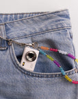 Mini digital camera in jean pocket with rainbow beaded lanyard clip