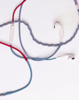 Braided wired earphones with white in-ear tips and a white inline remote, featuring blue, red, and gray braided cable strands on a plain white background.