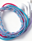 Braided wired earphones with a colorful twisted cable in turquoise, purple, pink, and silver, shown with white earphone tips on a white background.