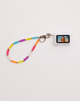 Mini digital camera with rainbow beaded lanyard showing photo on screen