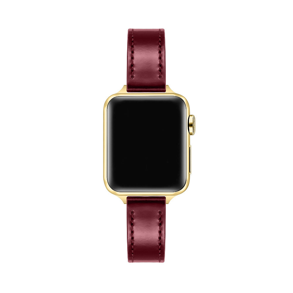 Apple Watch with Cherry Lacquer patent leather band, top-down view showing gold case and black face