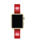 Apple Watch with Crimson patent leather band, top-down view showing gold case and black face