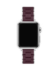 A silver smartwatch with a dark burgundy silicone link band, shown against a solid white background.