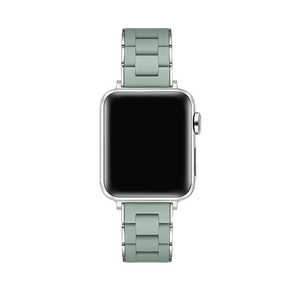 A silver smartwatch with a rectangular black screen and a light sage green metal link band, shown against a plain white background.