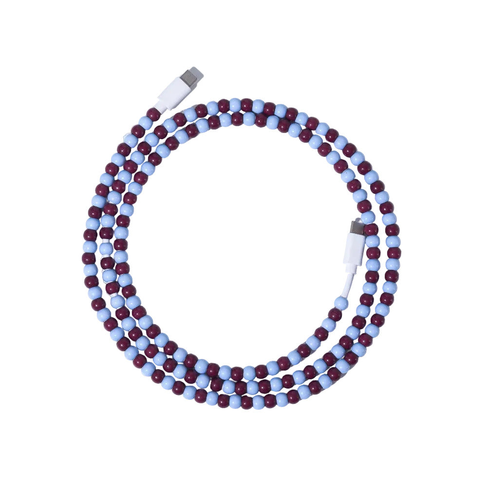 Burgundy and light blue USB-C beaded charging cable coiled on lavender background