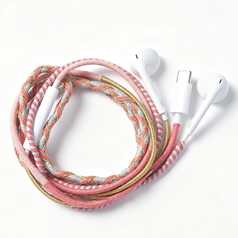 A braided multi-colored charging cable with white earbud-style connectors, coiled on a clean white background.