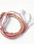 A braided multi-colored charging cable with white earbud-style connectors, coiled on a clean white background.