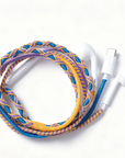 A braided multi-colored charging cable with white earbud-style connectors, coiled on a clean white background.