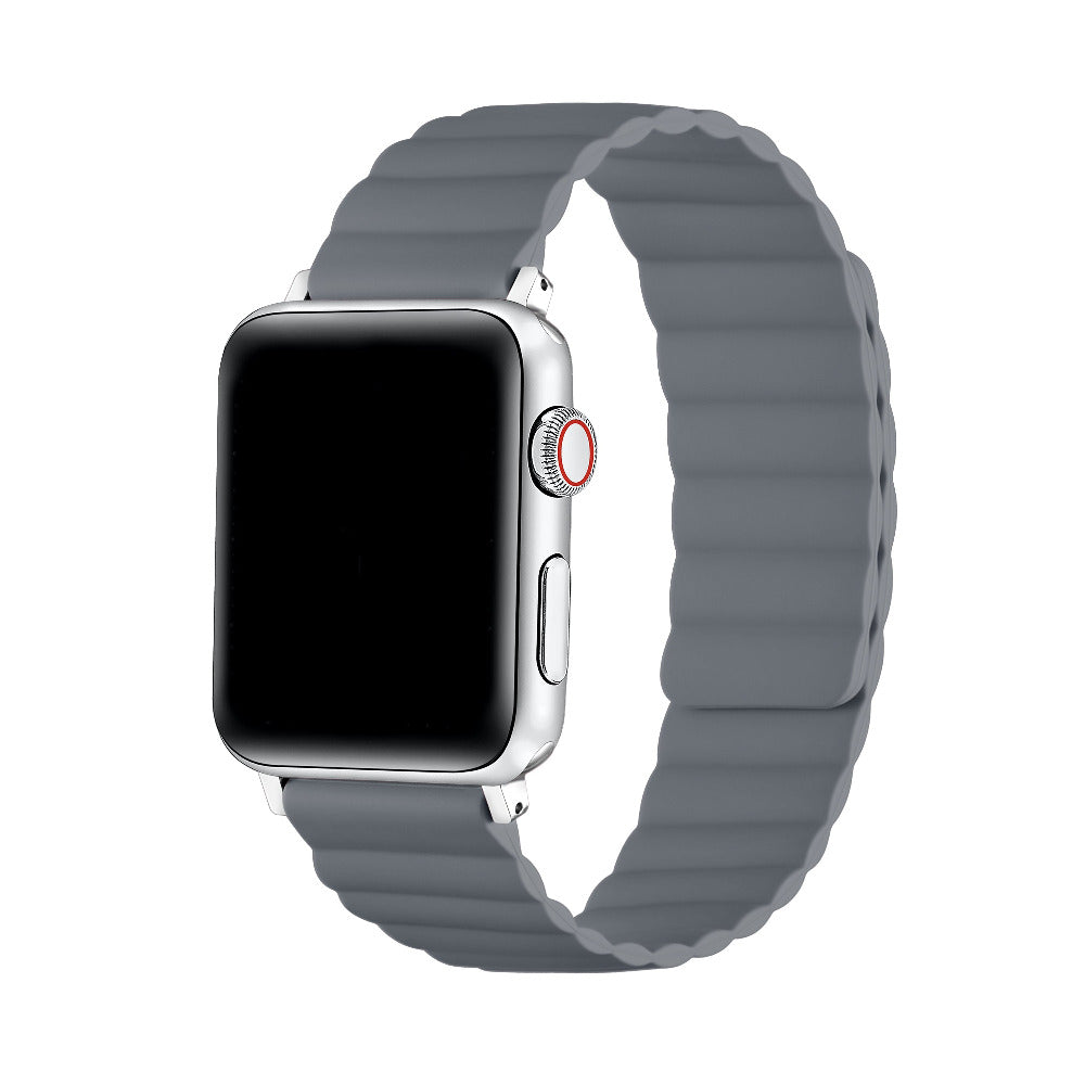 A silver smartwatch with a rectangular black screen and a gray wavy silicone band, shown on a plain white background.