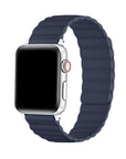 A silver smartwatch with a dark navy blue silicone strap featuring a wavy, ribbed texture, shown on a solid white background.