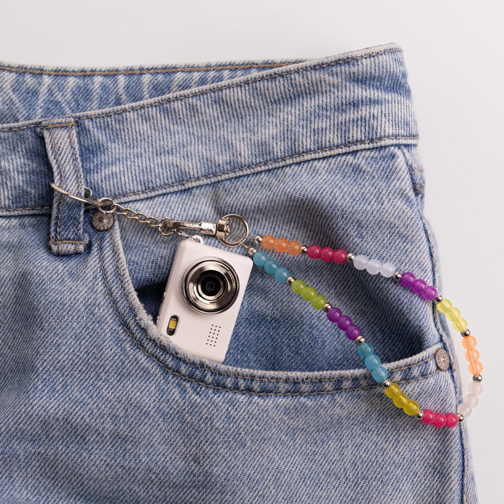 Mini digital camera in jean pocket with rainbow beaded lanyard clip