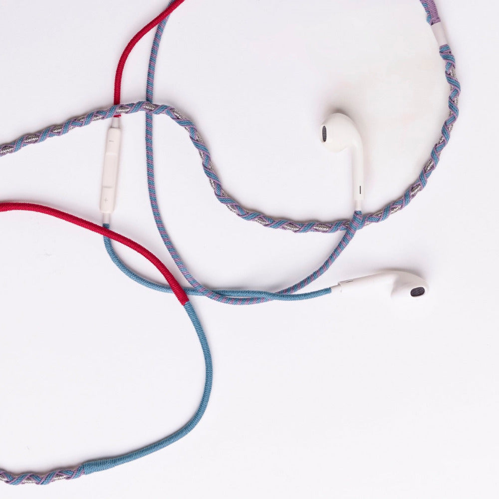 Braided wired earphones with white in-ear tips and a white inline remote, featuring blue, red, and gray braided cable strands on a plain white background.